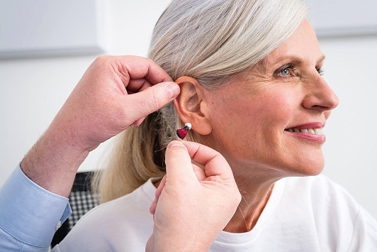 Seniorin erhält ein modernes Hörgerät zur Verbesserung ihres Hörvermögens im Alltag.